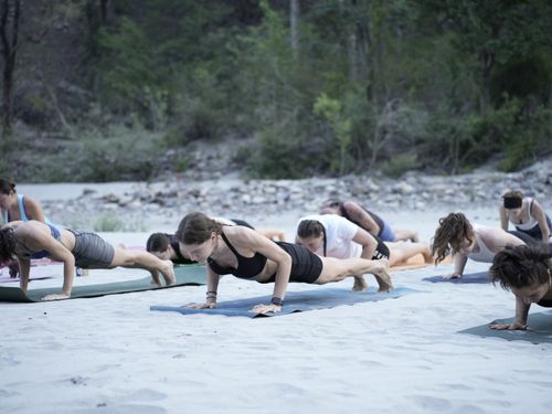 Free A group practicing yoga on a beach in Bali, Indonesia, surrounded by lush greenery. Stock Photo