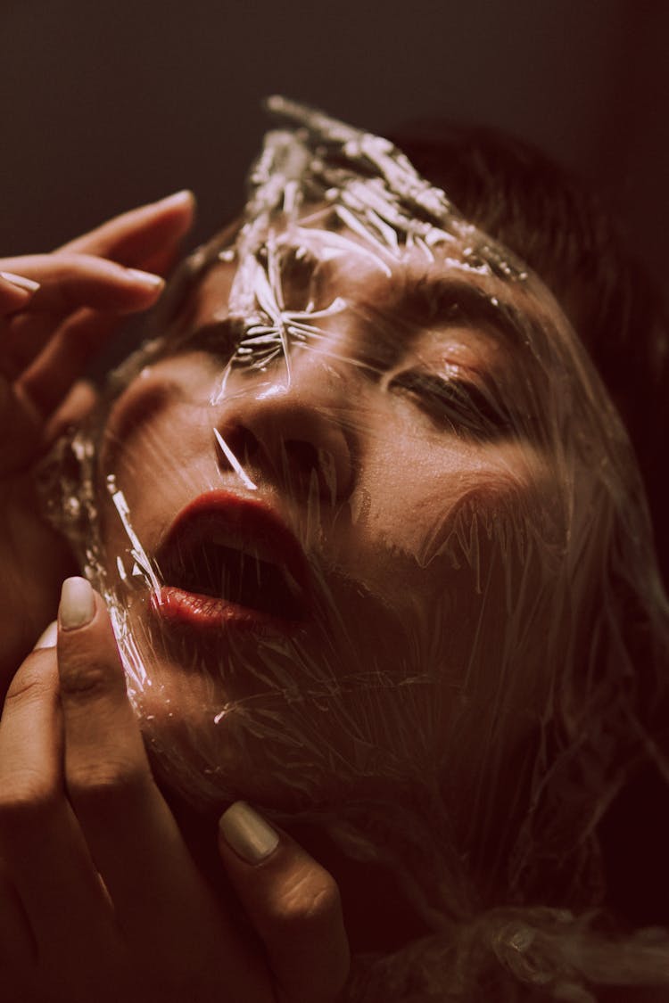 Close-up Photo Of Woman Posing With Cling Wrap On Her Face