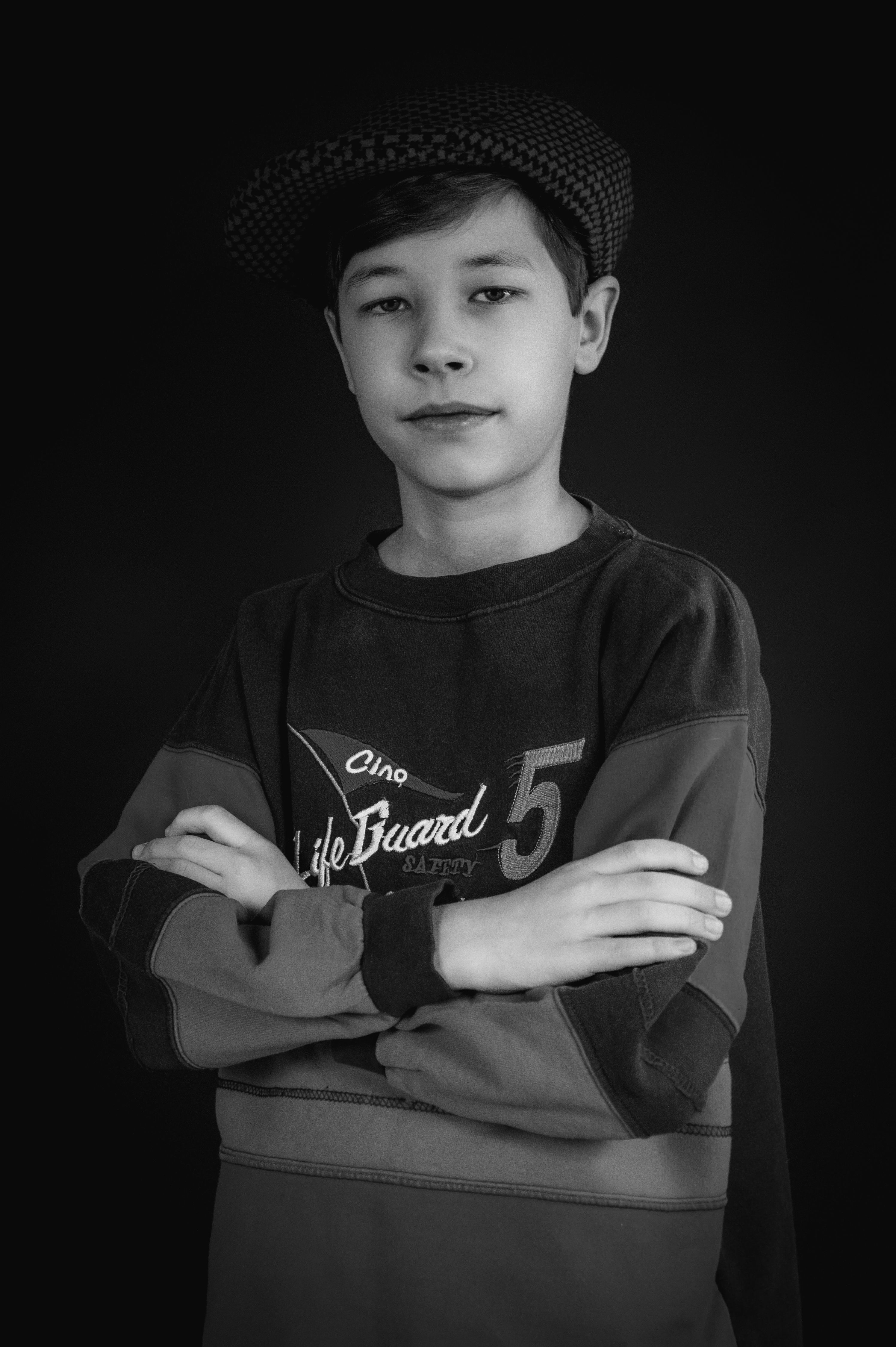 Um retrato em preto e branco de um menino usando um boné, exalando um clima retrô.