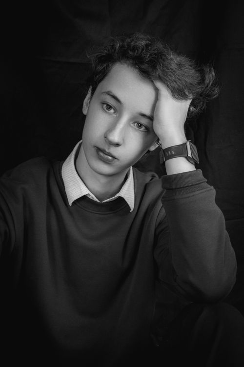 Free Black and white portrait of a young man sitting in a thoughtful pose. Stock Photo