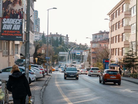 Busy street scene in Ankara with cars, modern architecture, and commercial buildings.