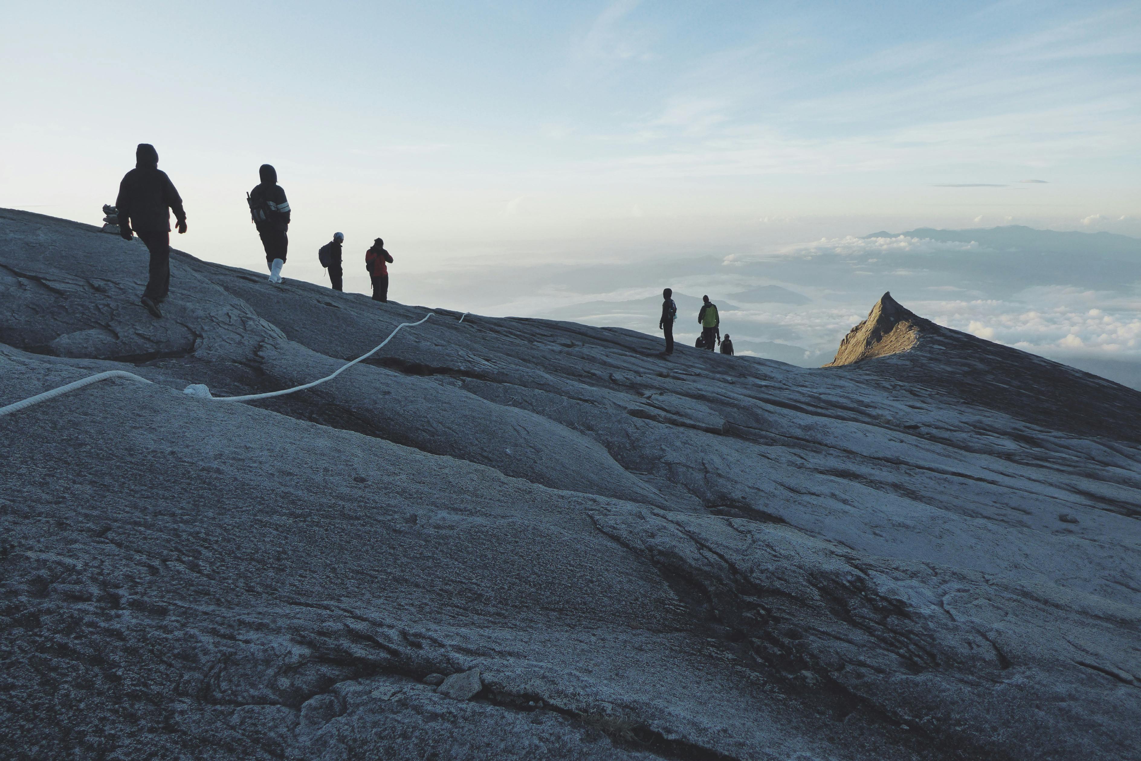 view photography of people climbing on mountain