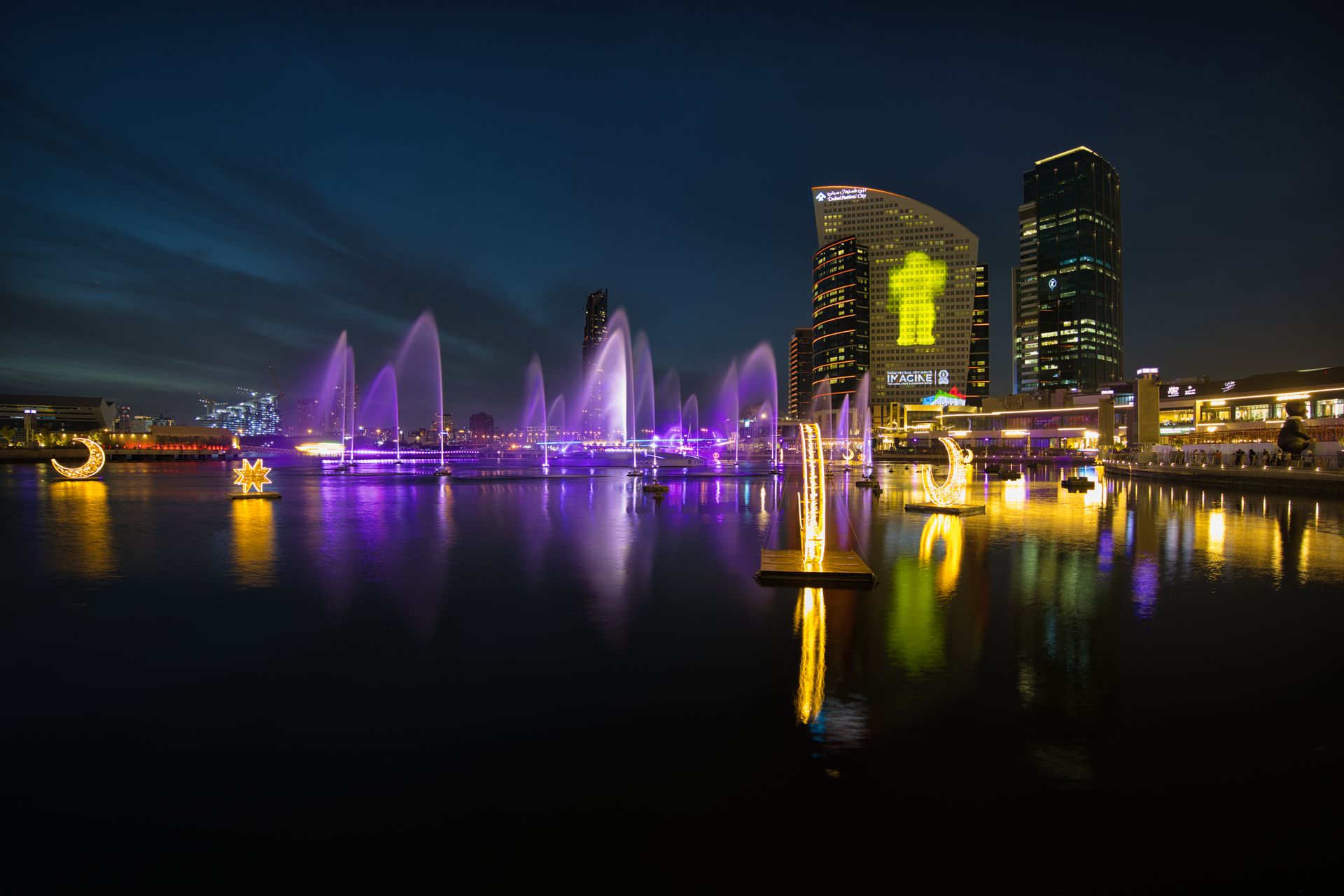 Vibrant night scene of illuminated fountains and skyscrapers in Dubai.