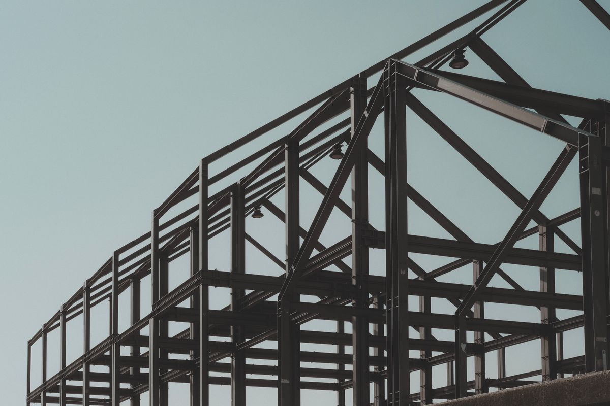 Modern steel framework structure rising against clear sky — precision architectural construction