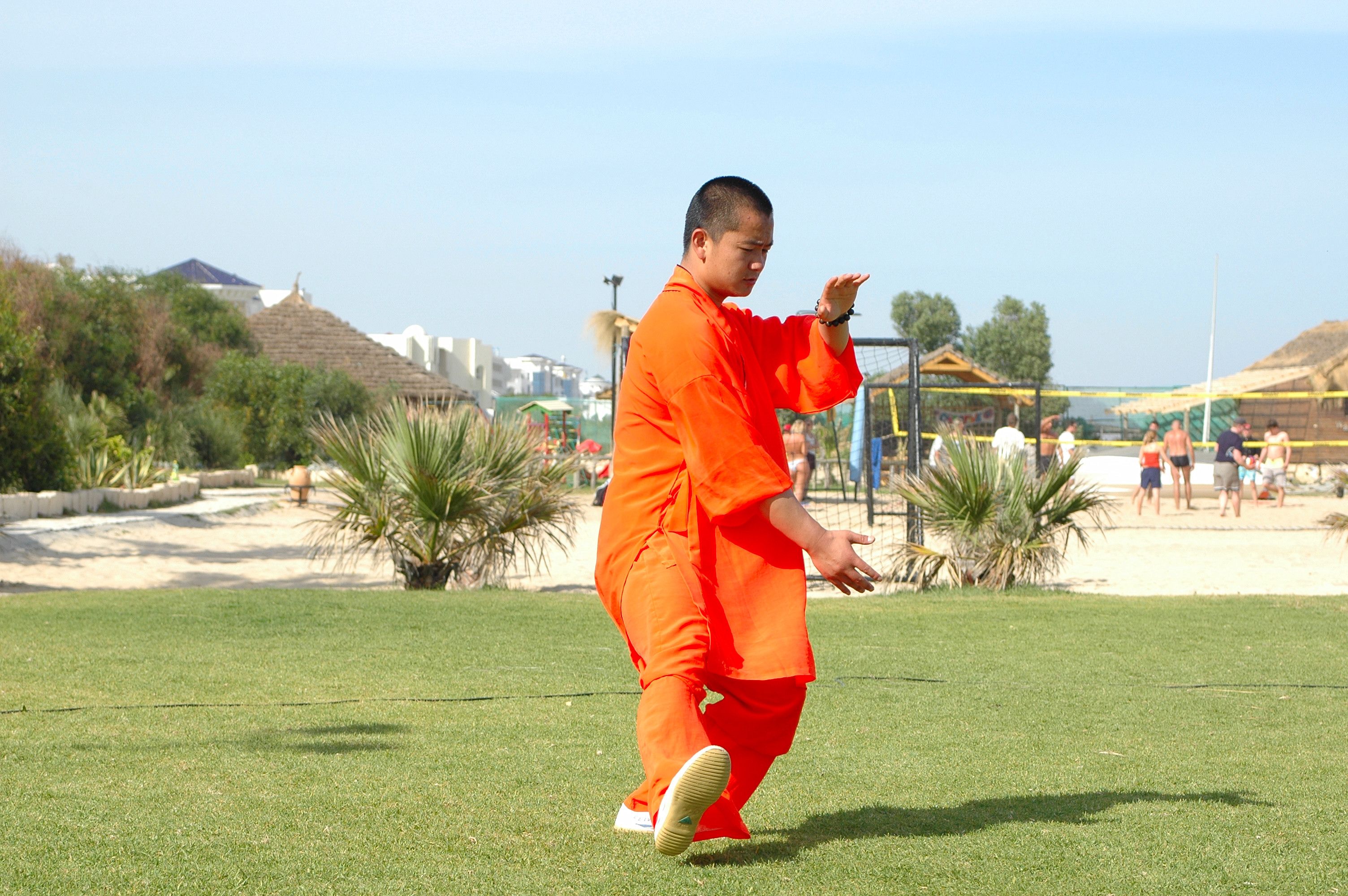 Martial Artist in Orange Robes Practicing Outdoors · Free Stock Photo