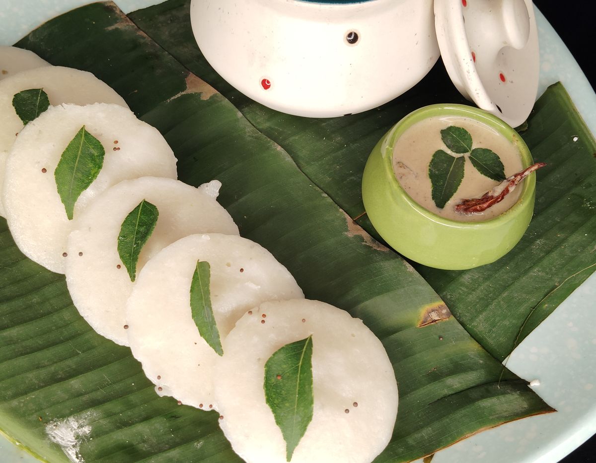 Idli with sambar and coconut chutney on banana leaves