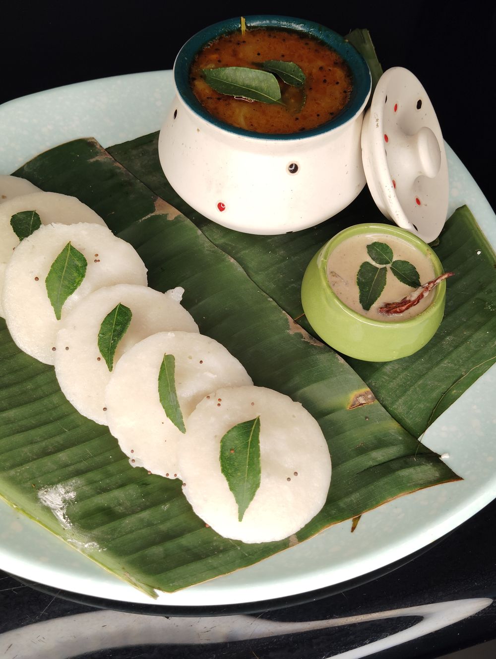 Soft idli served with sambar and coconut chutney