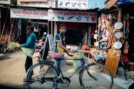 一名骑着自行车的青少年在充满活力的城市市场上，展示了当地的商店和街头小贩