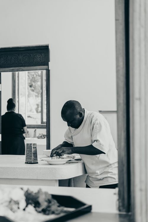 Free A chef skillfully prepares food at a countertop in a modern kitchen setting. Stock Photo