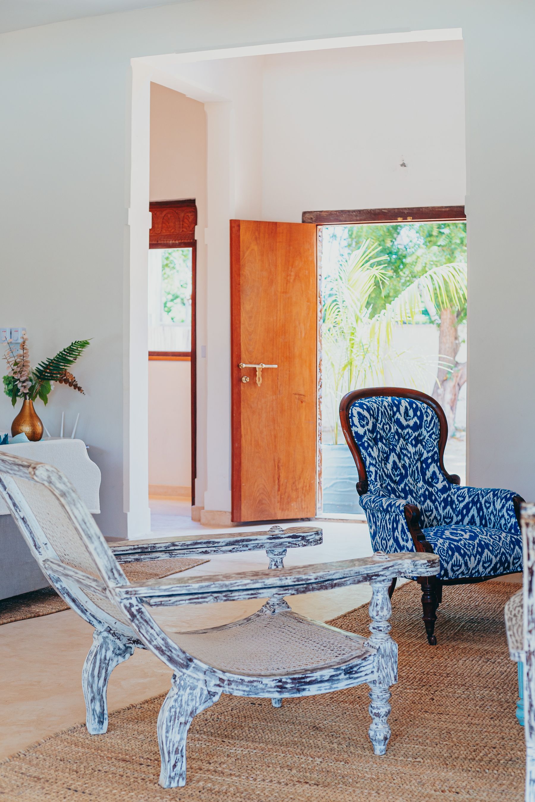 Bright airy living room with open door, natural light, plants and light summer styling