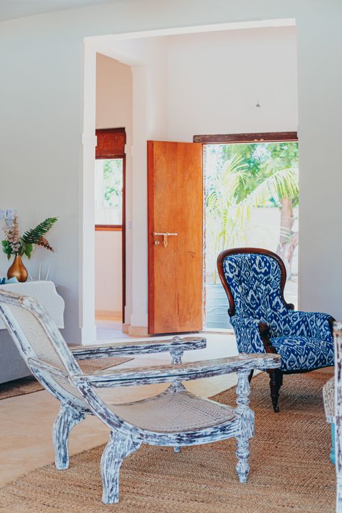 Free A well-lit modern living room with chic furniture and an open wooden door. Stock Photo