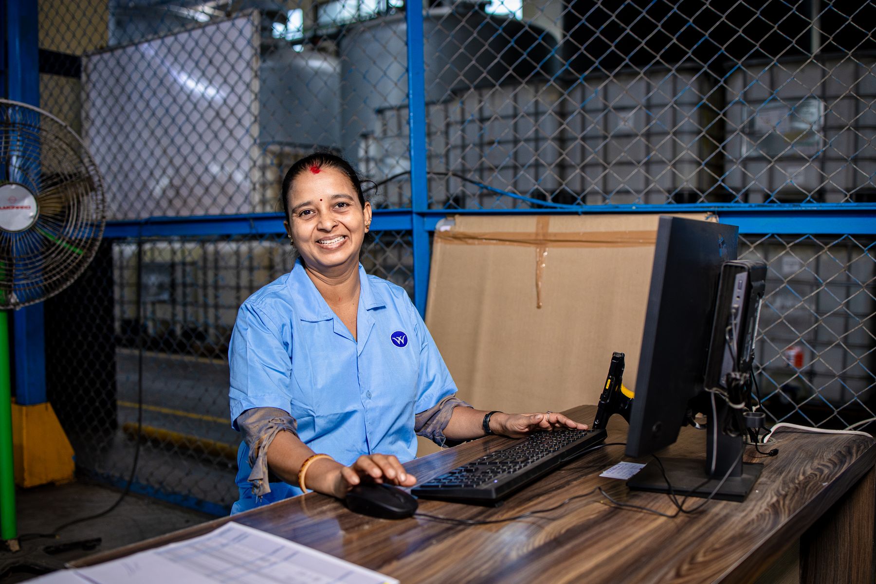 Indian factory worker using a computer in an industrial setting