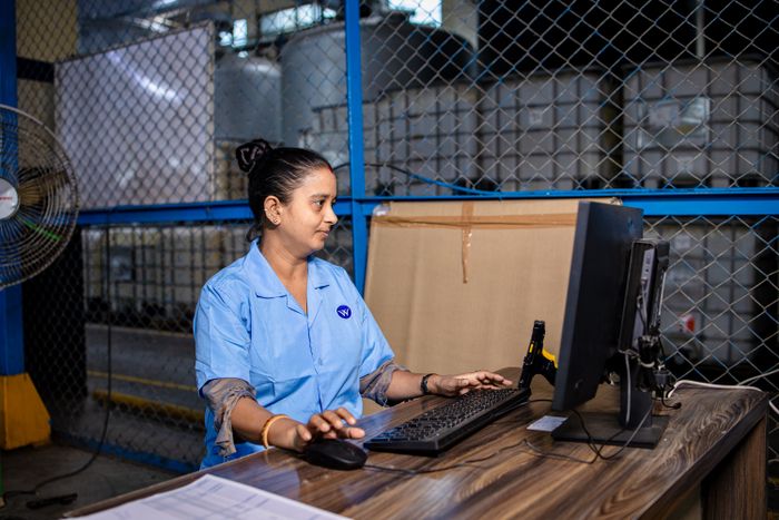 Factory worker using a computer in an industrial manufacturing setting