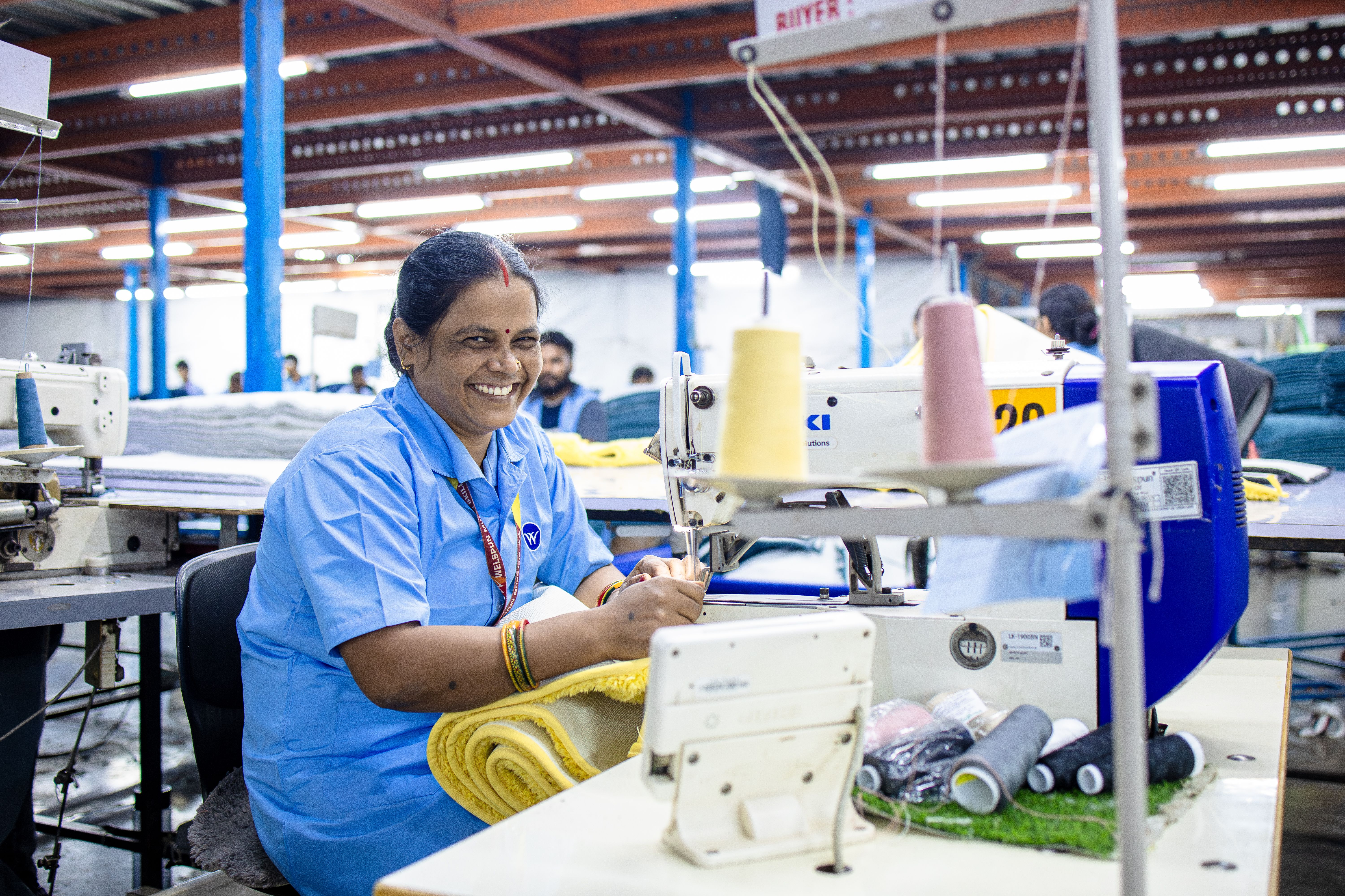 Smiling Textile Worker at Sewing Machine in Factory · Free Stock Photo