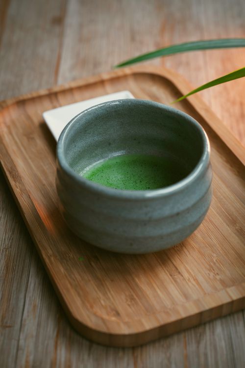 Free A serene setup of matcha tea in a ceramic bowl on a bamboo tray, capturing a peaceful tea moment. Stock Photo