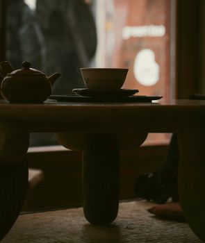 Ceramic teapot and bowl on wooden table during a Japanese tea ritual in Berlin.
