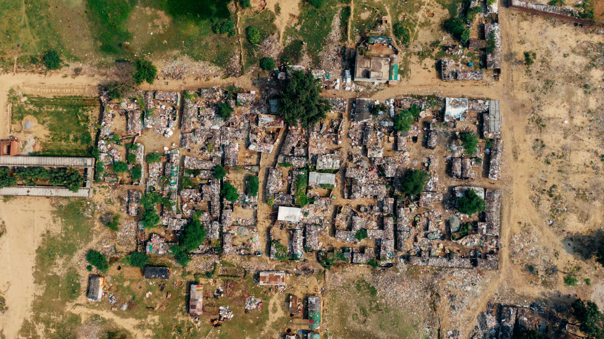 Aerial image showcasing dense urban settlement with makeshift structures and greenery.