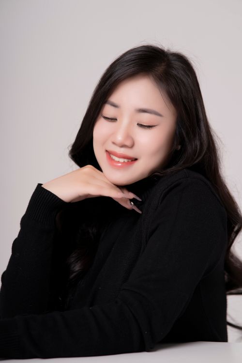 Gratuit Un portrait serein d'une femme souriante, les yeux fermés, vêtue d'une tenue noire. Photos
