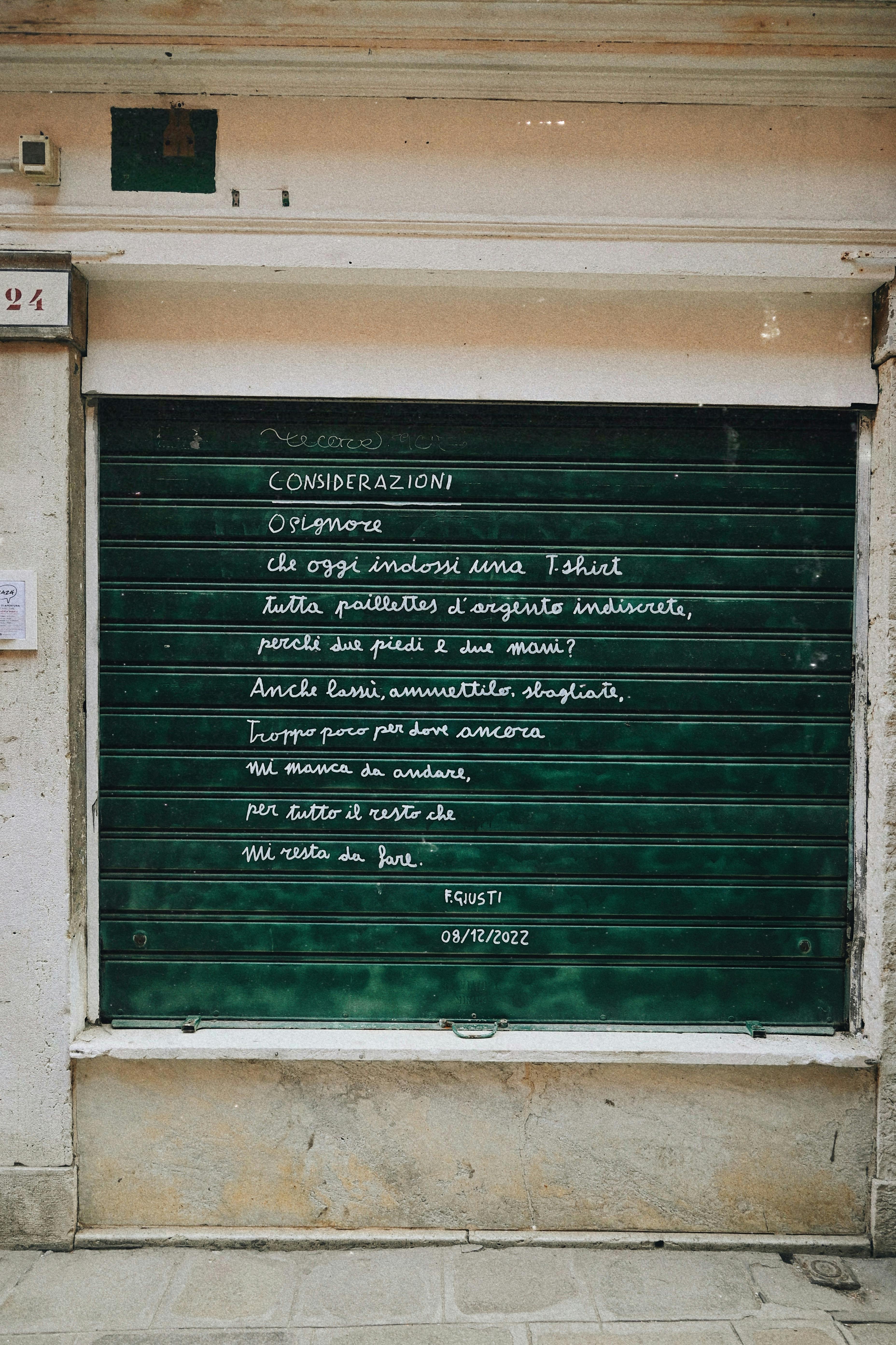 Charming Venetian shop facade with handwritten poetry on a weathered door.