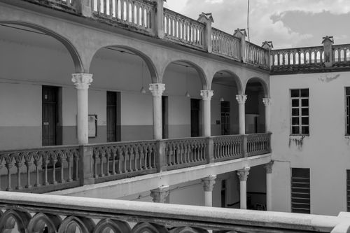 Free Monochrome photo of an upper-level open corridor in a historical building. Stock Photo