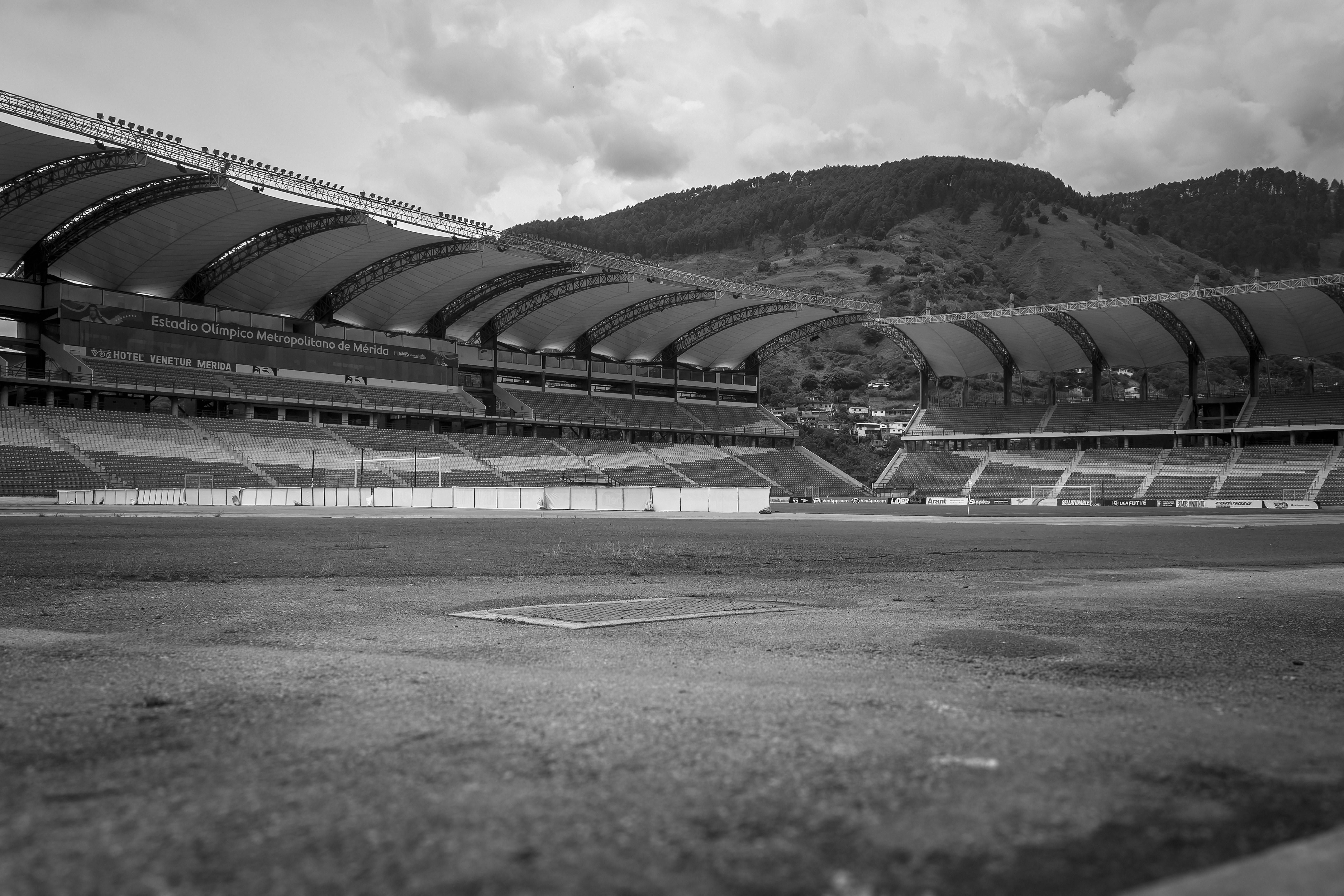 Monochrome view of Estadio Olímpico Metropolitano, showcasing its architecture and mountainous backd