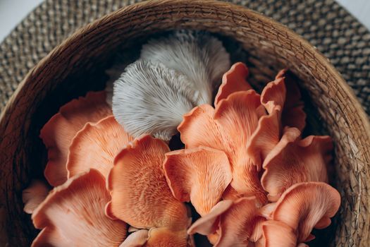Detailed view of oyster mushrooms in a woven basket, showcasing their texture and color.