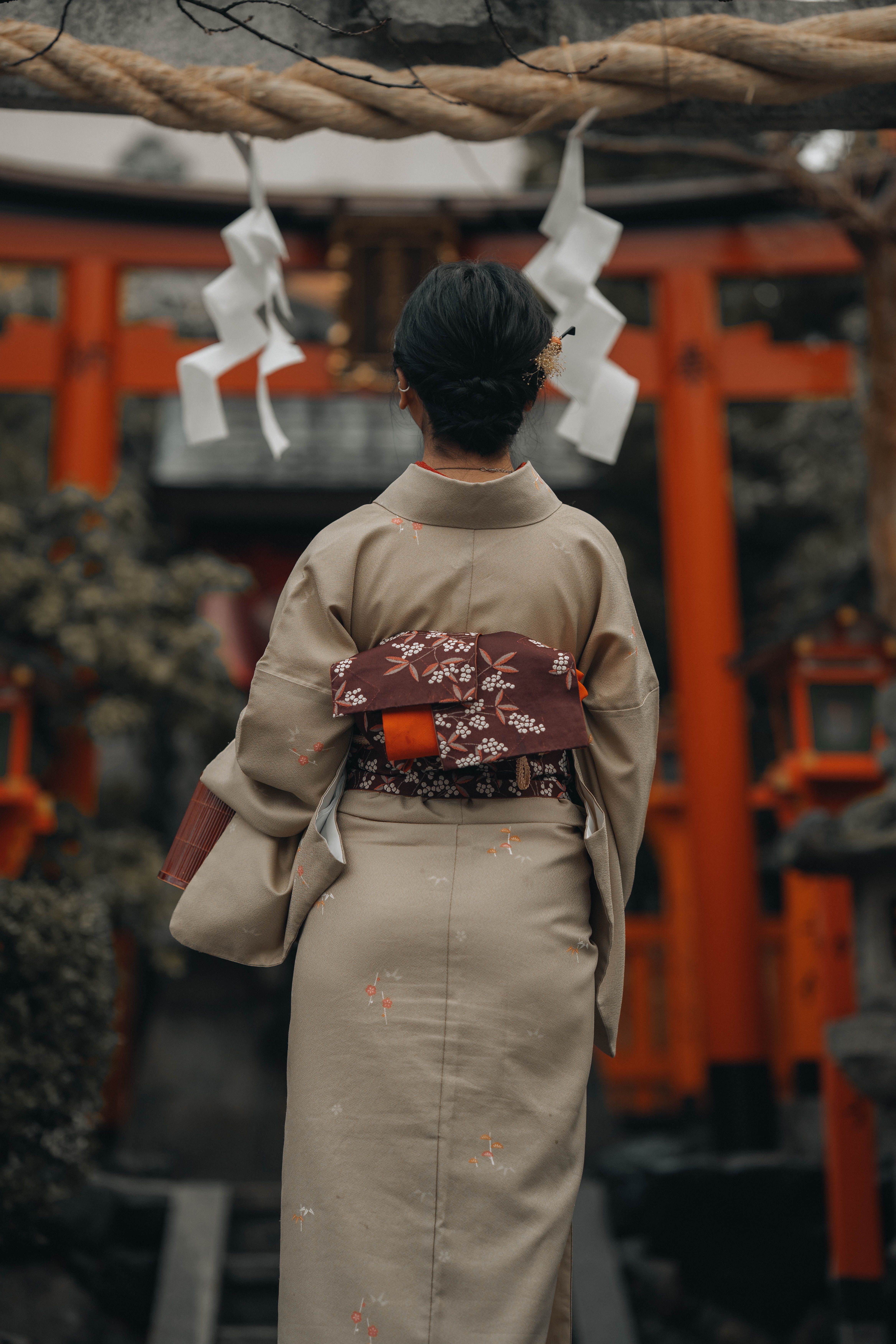 Japanese woman in kimono standing at a shrine entrance in Kyoto, Japan.