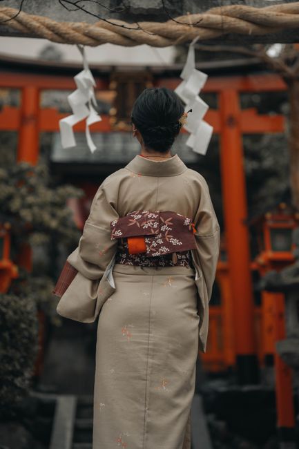 Japanese woman in kimono standing at a shrine entrance in Kyoto, Japan.