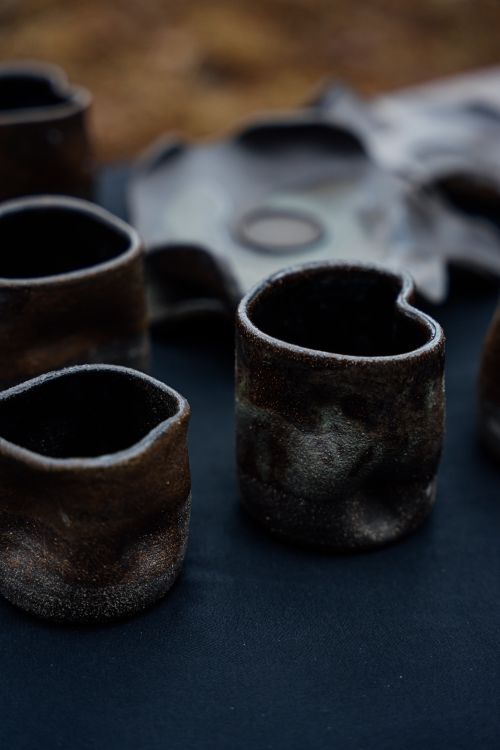 Free Close-up of rustic handmade ceramic mugs showcasing unique textures and earthy tones. Stock Photo