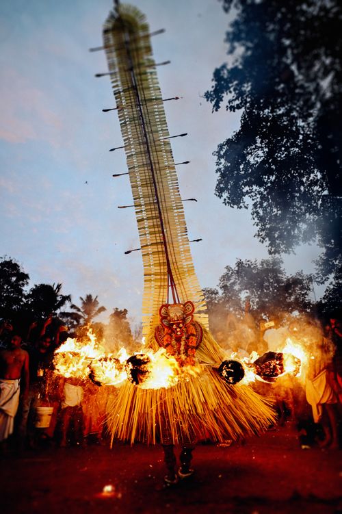 Free Vibrant fire dance performance in traditional attire with flames in an outdoor setting at dusk. Stock Photo
