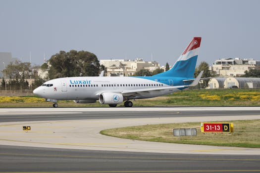 Luxair aircraft taxiing on runway at airport, showcasing travel and aviation themes.