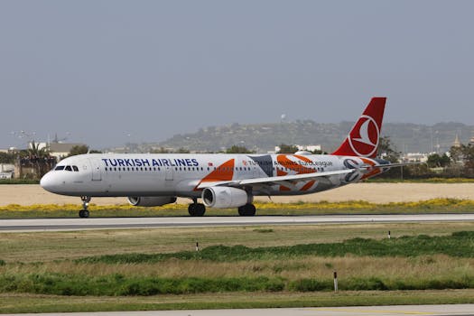 Airplane from Turkish Airlines taxiing on the runway during the day.