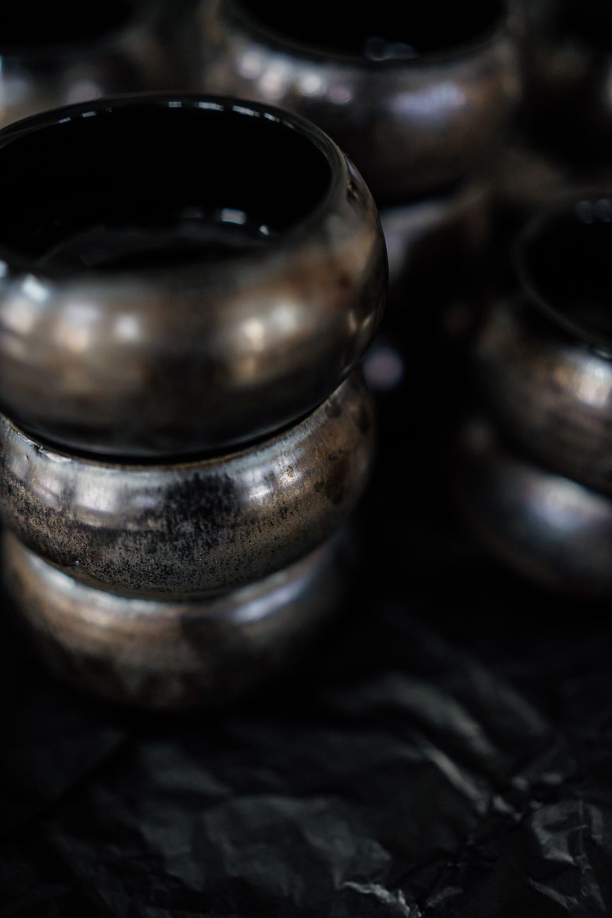 Beautifully stacked handmade clay pots showcasing artisanal craftsmanship in a moody setting.