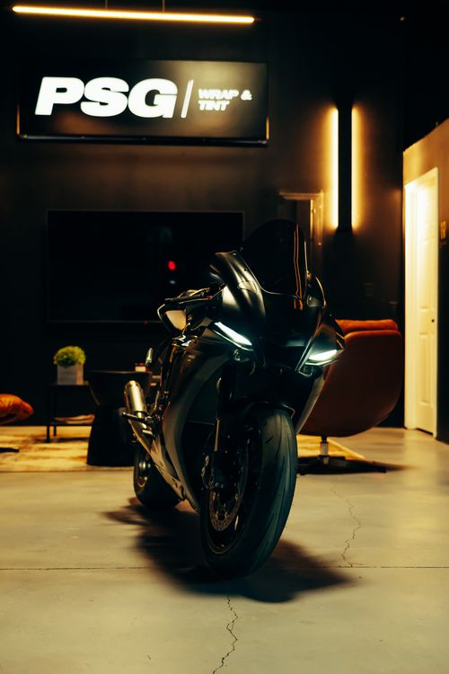 Free A glossy black motorcycle parked indoors, exuding a modern and stylish mood. Stock Photo