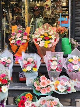 Vibrant floral bouquets with daisies and gerberas on display outside an urban flower shop.