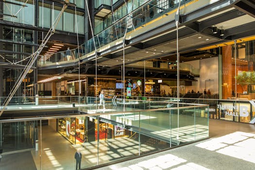 Bright interior of a contemporary shopping mall in London, with glass railings and retail spaces.