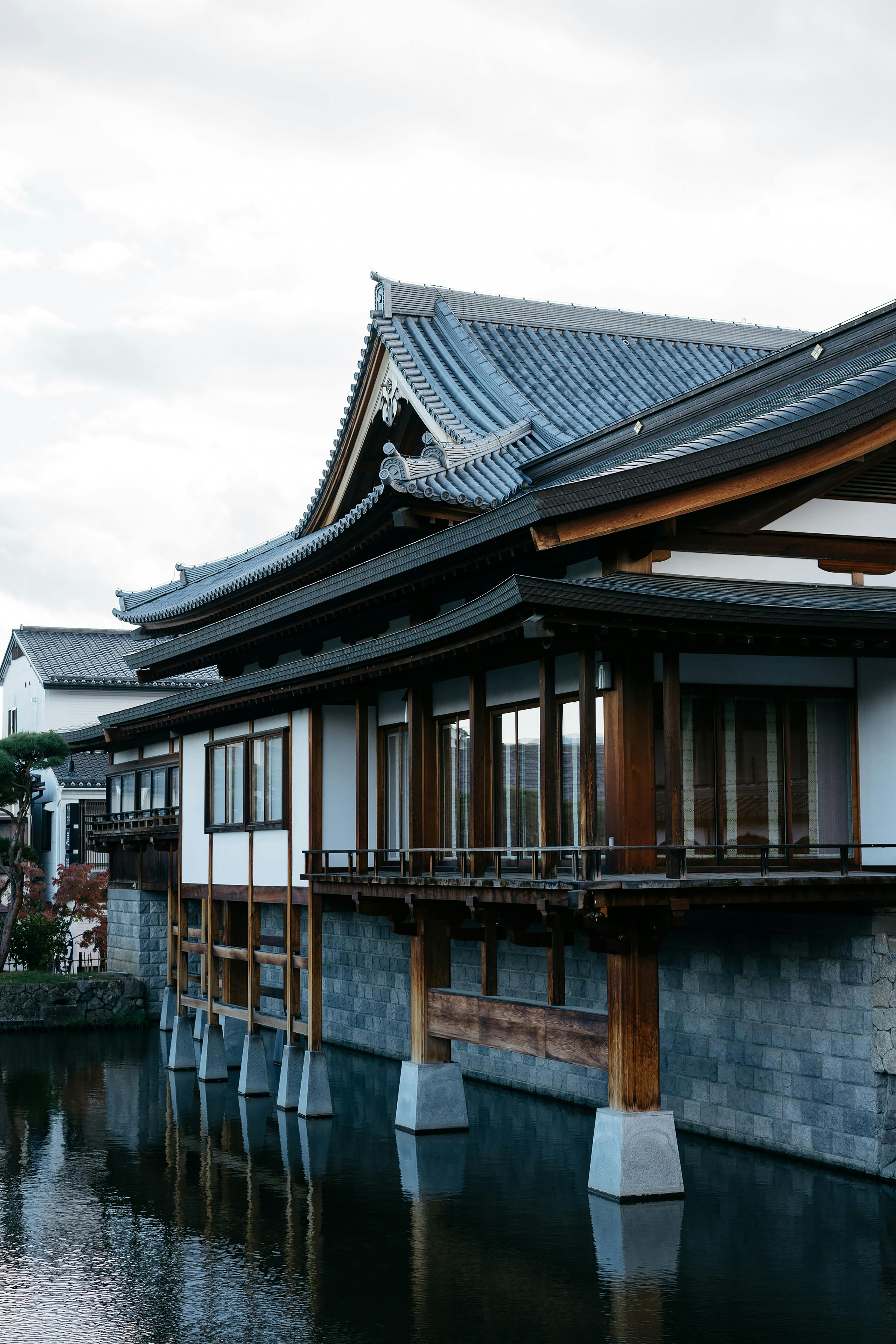 Elegant view of traditional Japanese building by the waterfront, showcasing wooden structure and cultural heritage.