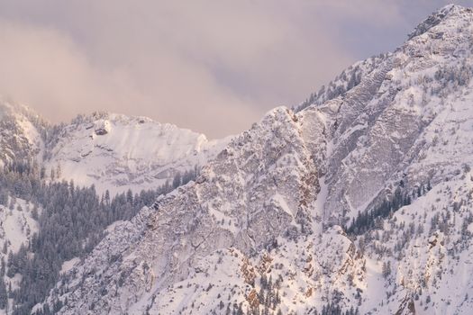 A breathtaking view of the snowy Wasatch Mountains near Salt Lake City during sunset.
