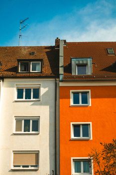 Vibrant residential building with contrasting colors and rooftop details.