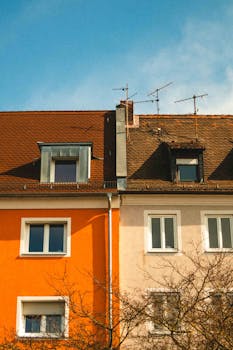 Vibrant residential building facade with rooftop antennas under a clear sky.