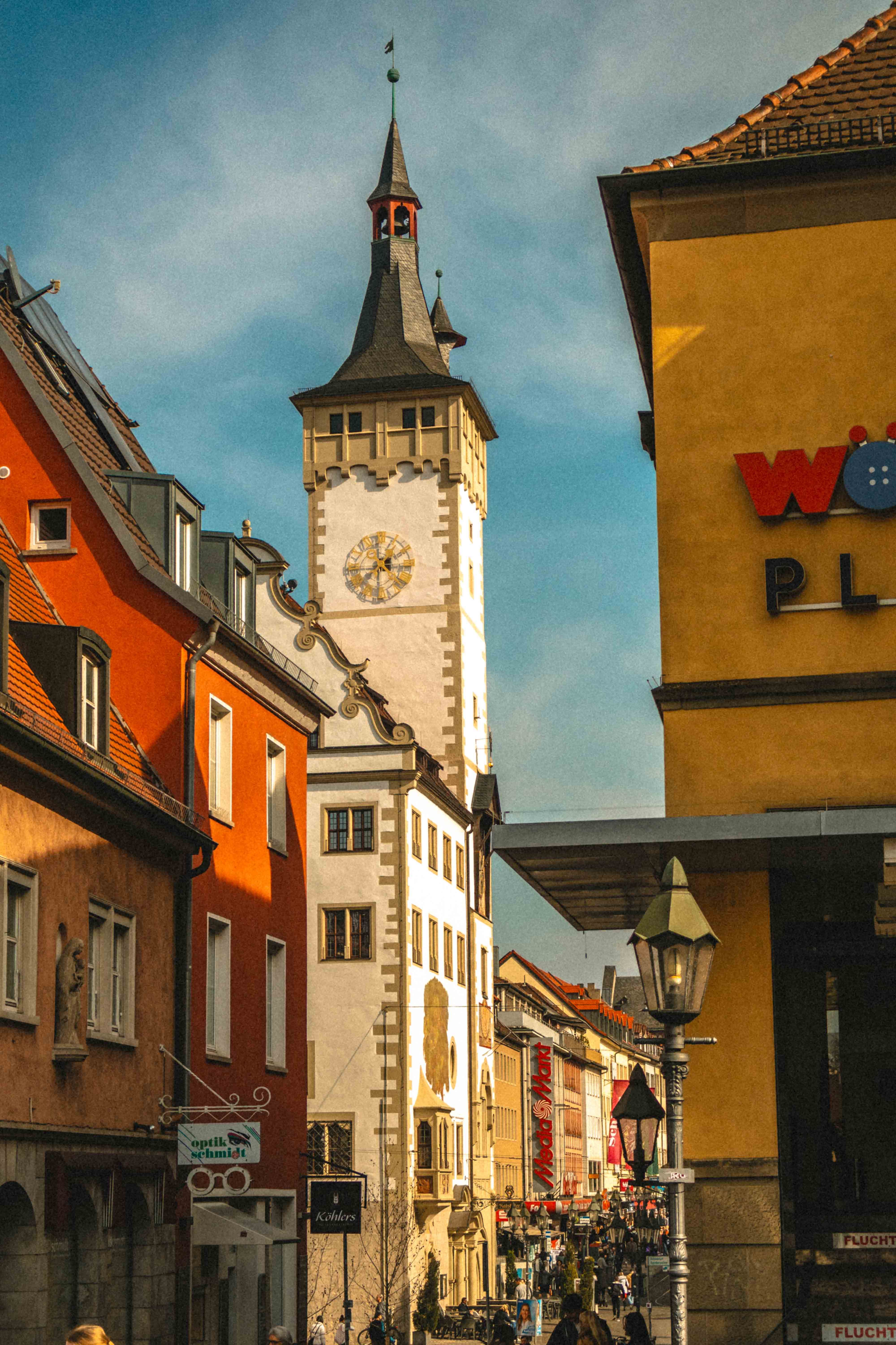 Cityscape of Würzburg showcasing historical buildings and vibrant street life under a clear sky.