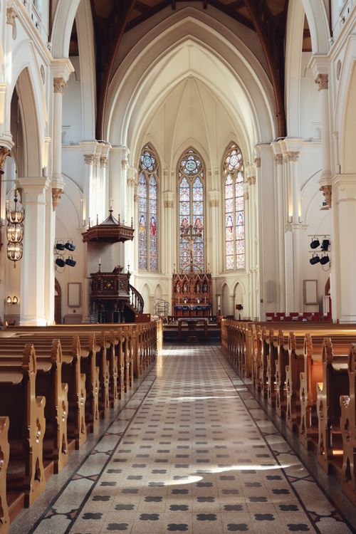 Free Serene church interior showcasing stunning Gothic architecture and stained-glass windows in Jönköping, Sweden. Stock Photo