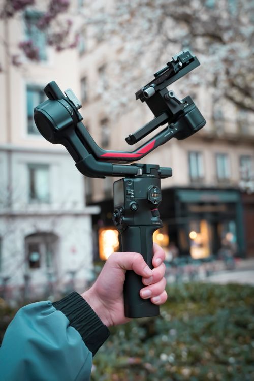 person holding camera gimbal outdoors