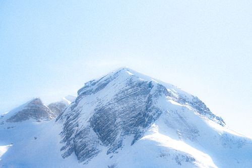 Free Majestic snowy mountain peak under a bright blue sky, perfect for winter themes. Stock Photo
