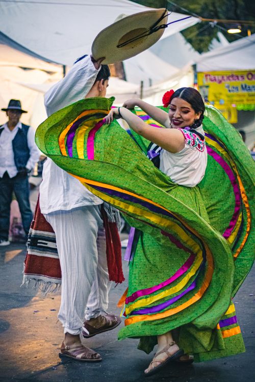 Free Dynamic Mexican folkloric dance captured on city streets, showcasing cultural vibrancy and traditional attire. Stock Photo