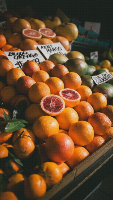 Eye-catching display of ripe blood oranges at an outdoor market. Freshness and color pop.