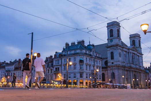A tranquil evening scene on the streets of Besançon, France, with city lights and historic architecture.