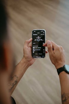 Close-up of hands using a smartphone app for data analysis indoors.