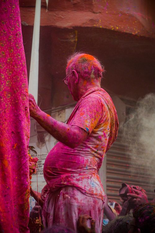 Free Elderly man immersed in Holi festivities, covered in colorful powder in Kolkata, India. Stock Photo