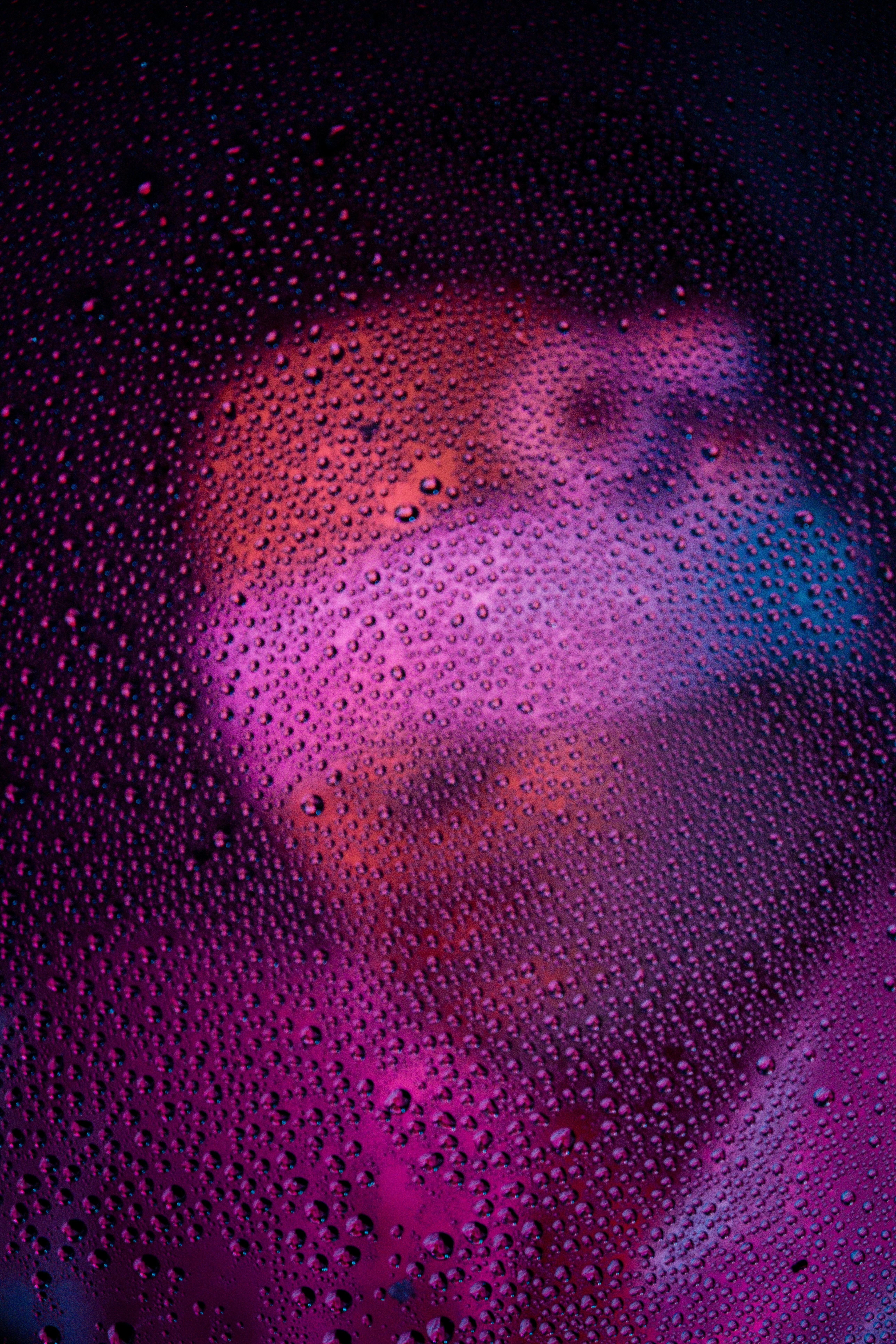 бесплатная Абстрактный портрет мужчины-модели, рассматриваемый сквозь капли воды с драматическим освещением. Стоковое фото